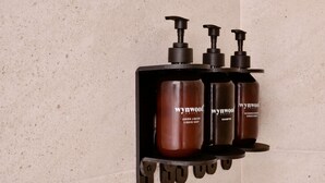 A bathroom shelf with three bottles of Wynwood House liquid soap, shampoo, and conditioner. - w Stunning Loft in Bogota (Bogotá)