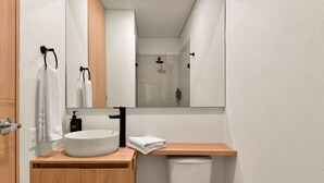 A modern bathroom with a white sink, wooden vanity, and a large mirror. - w Stunning Loft in Bogota (Bogotá)