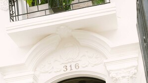 A person riding a bicycle with a basket, exiting a building with a white facade and the number 316. - w Suite in Casa Wynwood Miraflores (Lima)