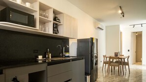 Una cocina moderna con microondas integrado, refrigerador y comedor con mesa y sillas.