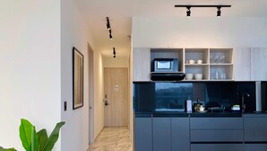 A modern kitchen with a built-in microwave, dark cabinetry, and a marble floor. - w Great 2BR w Ocean View Near C Amurallada (Cartagena)