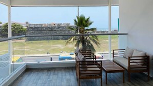 A balcony with a view of a fort, furnished with wooden chairs and a table. - w Great 2BR w Ocean View Near C Amurallada (Cartagena)