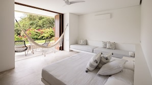 A modern bedroom with a large bed, a hammock, and a view of a lush garden. - w Mind-blowing 4BR Villa w Pool at Mesa de Yeguas (Anapoima)