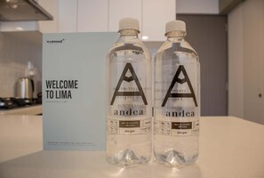 Two bottles of water labeled 'andea' with a welcome sign in the background.