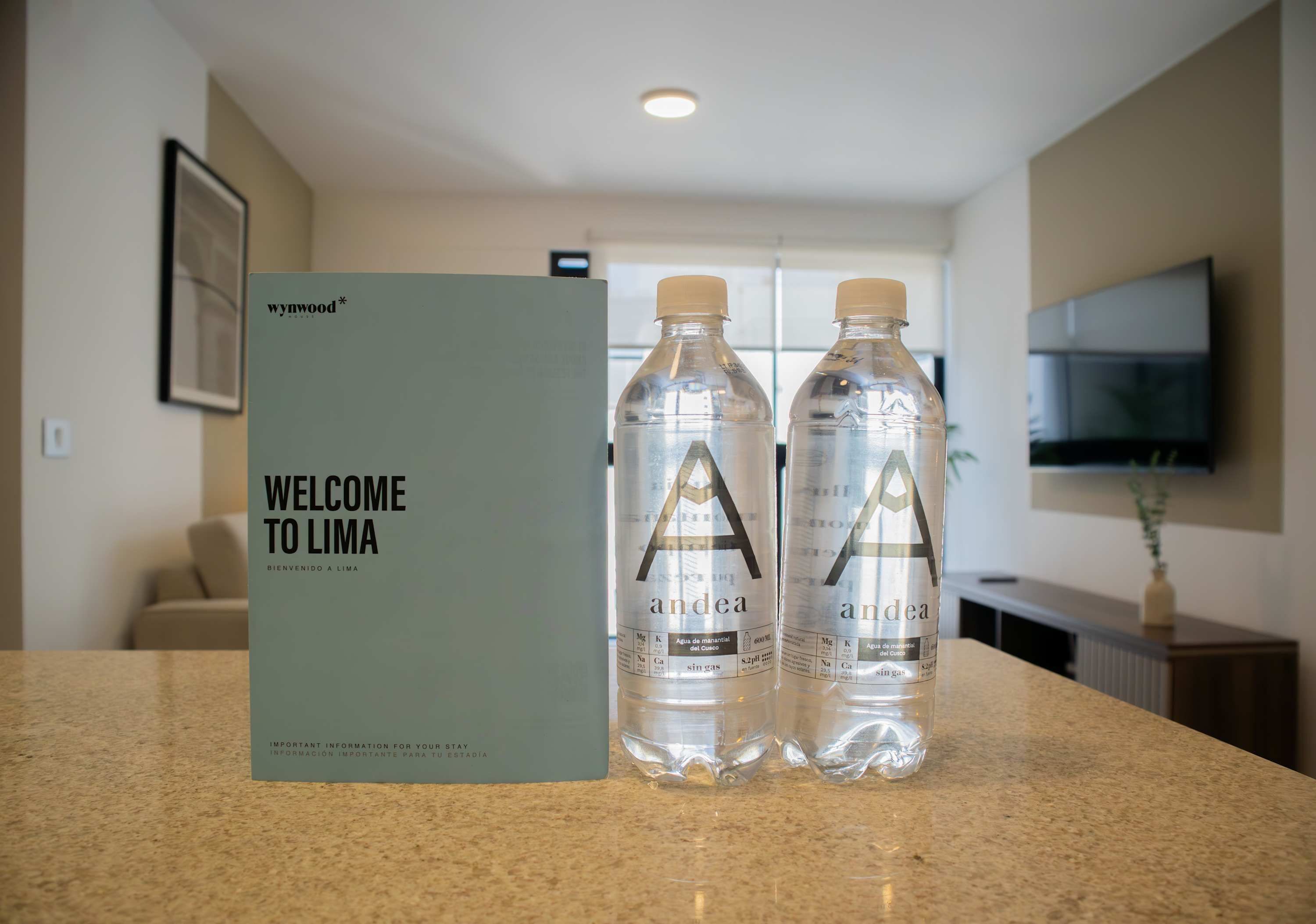 A welcome sign and two water bottles on a countertop.
