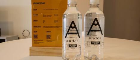 Two water bottles with labels and a welcome sign with information.