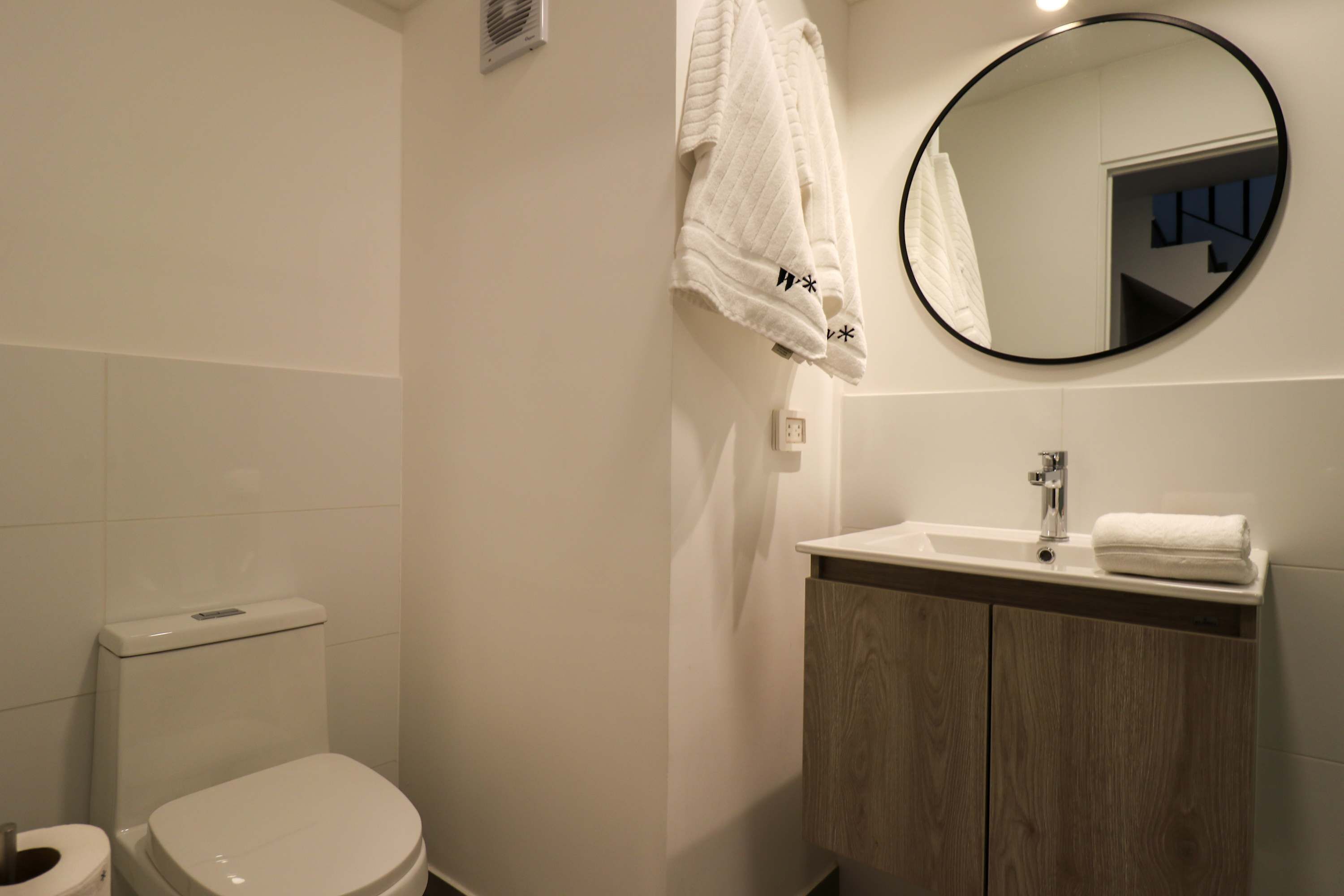 Une salle de bain moderne avec des toilettes, un lavabo et un miroir.