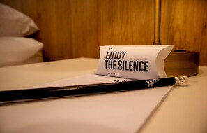 A piece of paper with the text 'ENJOY THE SILENCE' on a bed with a wooden headboard. - w Spectacular 1BR w Terrace in Miraflores (Lima)