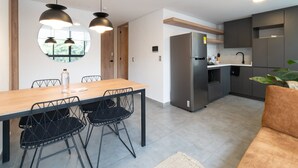 Una cocina moderna con una isla central, electrodomésticos de acero inoxidable e iluminación colgante.