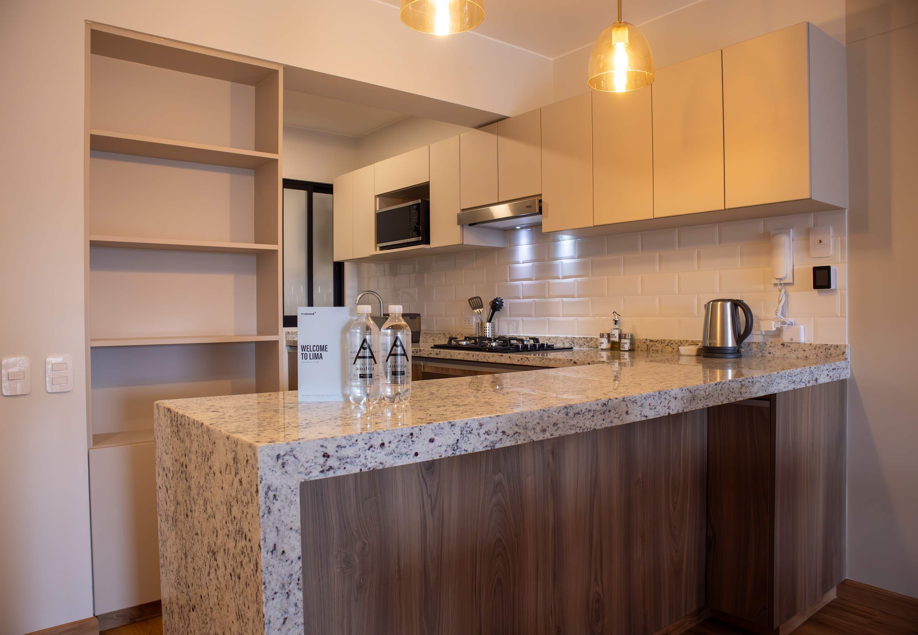 A modern kitchen with a granite countertop, stainless steel appliances, and wooden cabinetry.