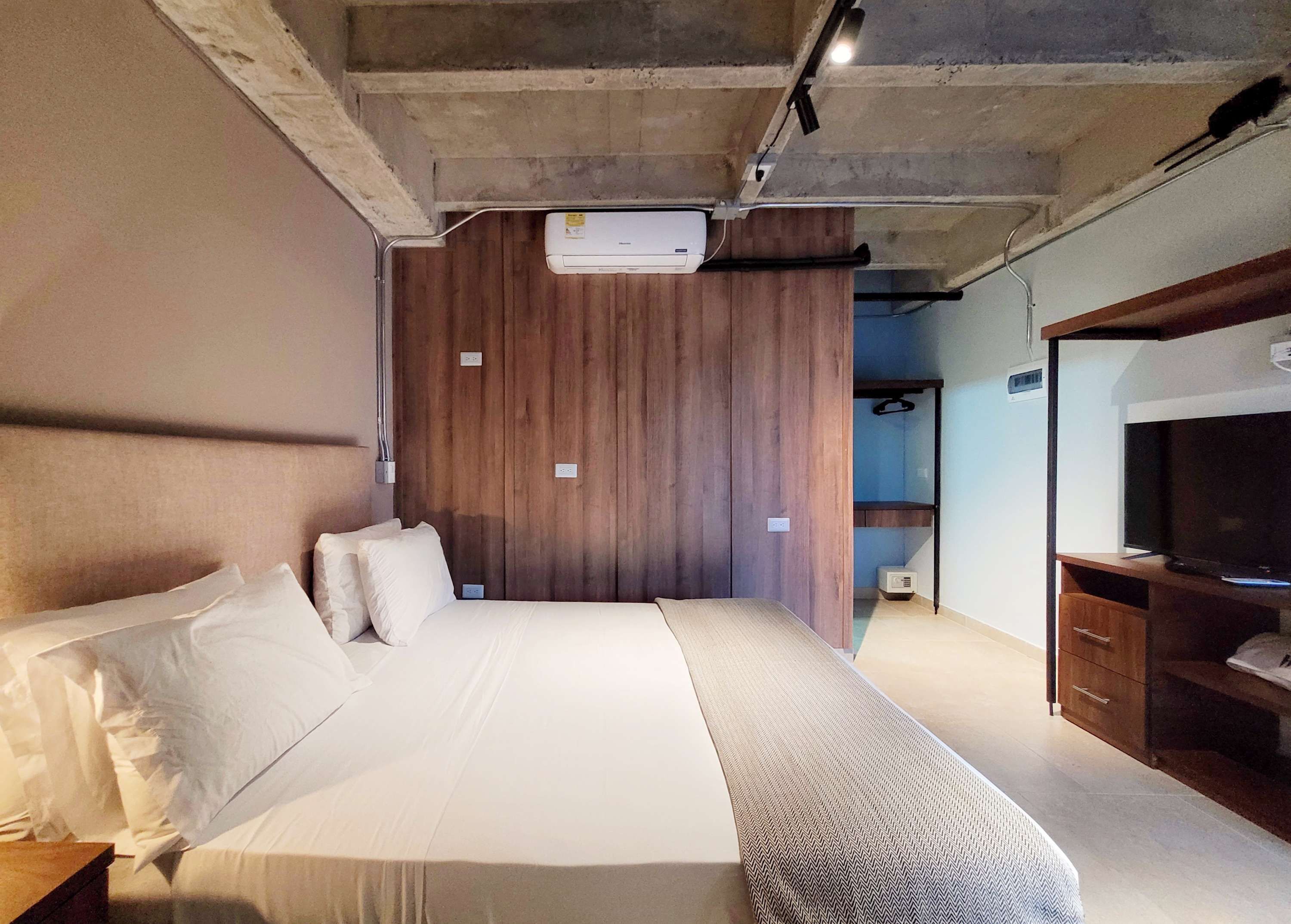 Camera da letto con un letto, una TV, un armadio e un condizionatore d'aria.