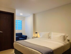 A hotel room with a bed, a chair, a nightstand, and a window with blinds. - w Breathtaking 2BR w AC in Cartagena (Cartagena)