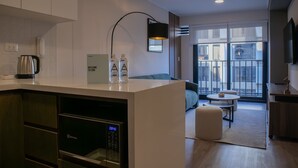 A modern kitchen with a built-in oven, a coffee maker, and a digital clock displaying 08:40. - w Gorgeous 1BR w Terrace in Miraflores (Lima)