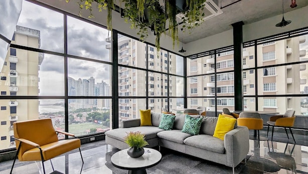 Uma sala de estar moderna com um sofá, cadeiras e uma mesa de centro.