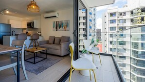 Um apartamento moderno com varanda, área de refeições, cozinha e sala de estar.