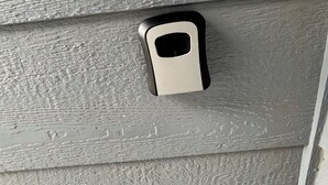 Gros plan d’une poignée de porte métallique sur un mur gris à texture.