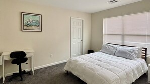 Une chambre à coucher avec un lit, un bureau et une chaise.