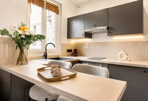A modern kitchen with a central island, a built-in stove, and a window with a view.