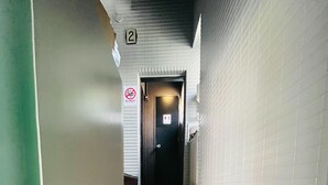 A staircase with wooden steps leading to a door marked with the number 2. - Ogikubo Tombo hotel (Tokyo)