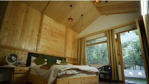 A wooden bedroom with a bed, bedside table, and a window with curtains. - Nine Apple Resort Dharali Harsil (Bhatwari)