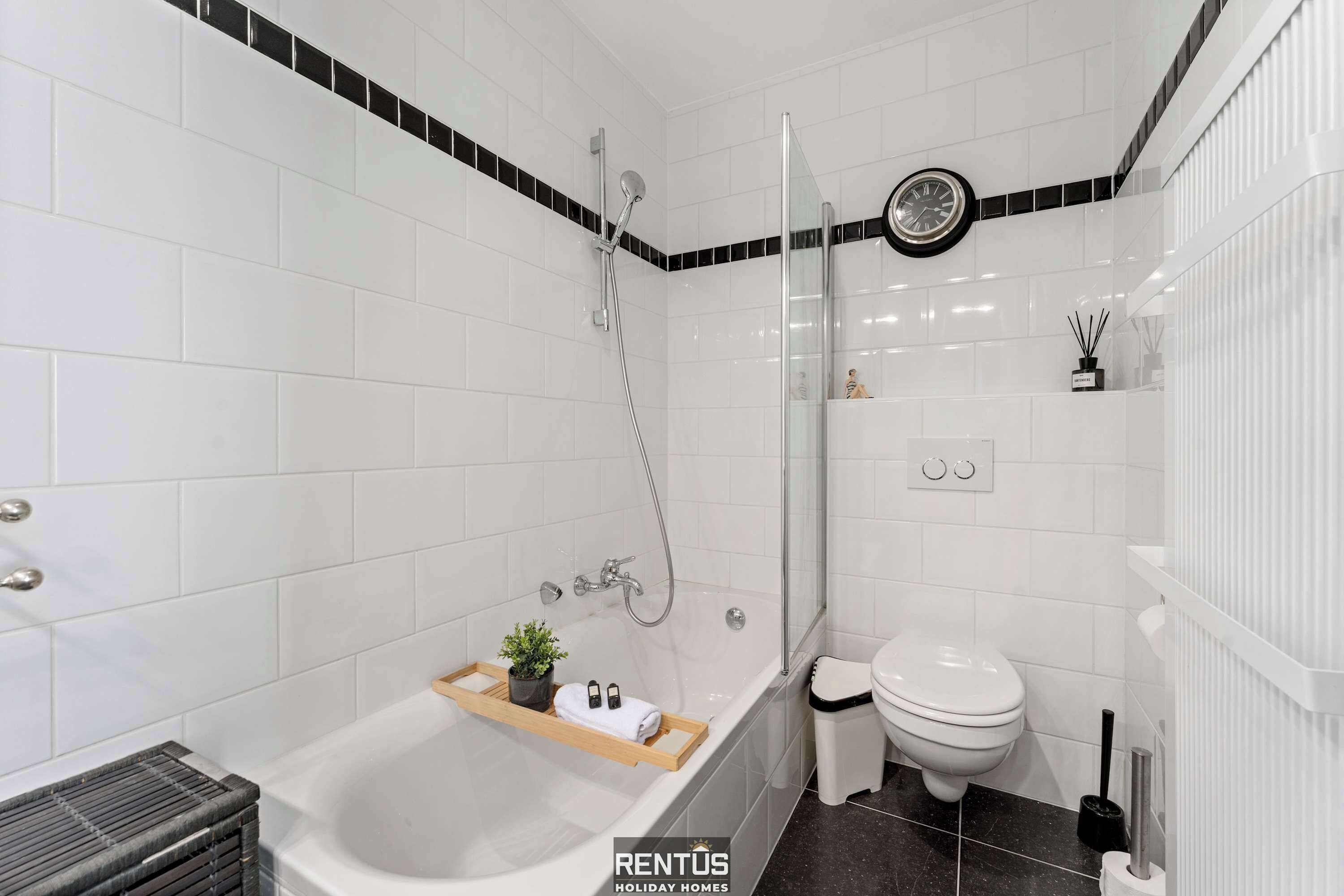 A modern bathroom with a bathtub, toilet, and shower.