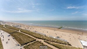 A beachside property with a paved walkway, beach access, and a view of the sea.