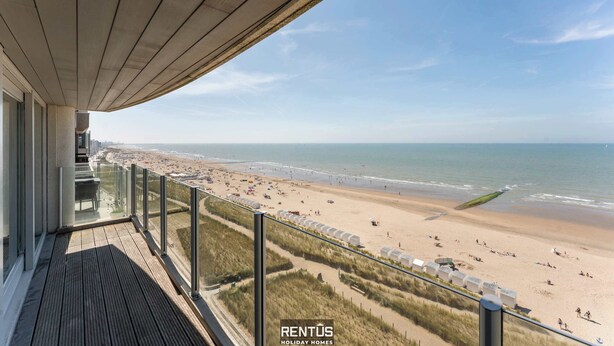 A balcony with a view of a beach and ocean.