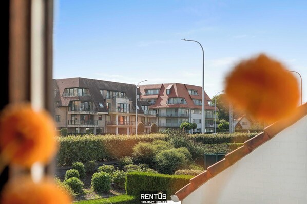 A modern residential building with multiple balconies and a well-maintained garden.