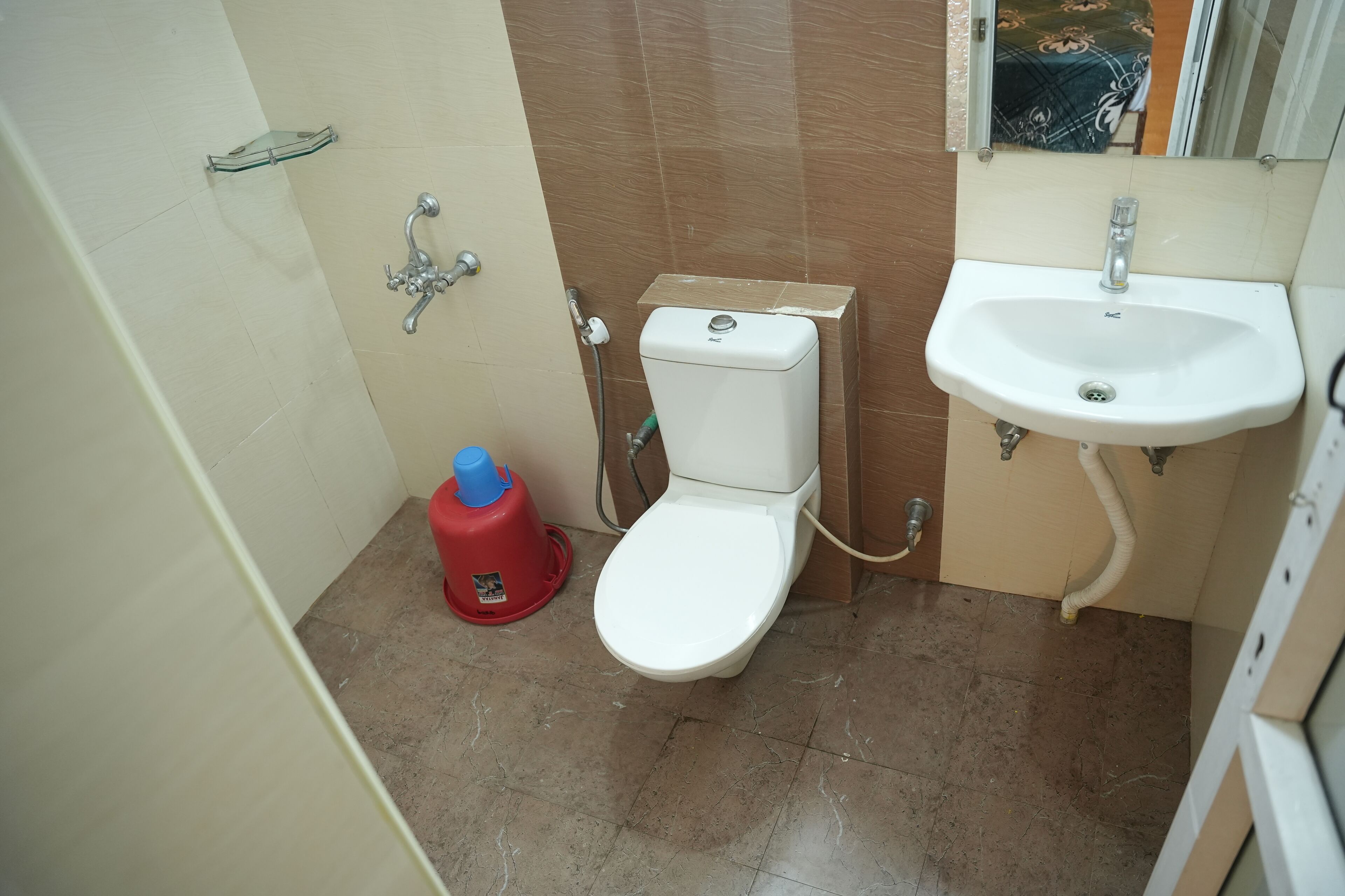 A small bathroom with a toilet, sink, and shower.