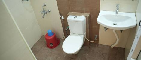 A small bathroom with a toilet, sink, and shower.