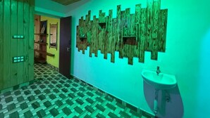 A hallway with a checkered floor, a wooden wall with vertical slats, and a sink on the right. - Misty 7-Bedroom Hill Retreat in Kodaikanal–Perfect for groups & Artists (Kodaikanal)