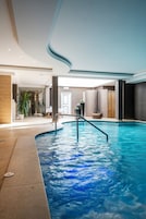 Una piscina techada, sillones reclinables de piscina