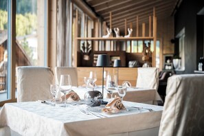 A dining table set with wine glasses, a silver bowl, and a lamp. - Hotel Antines (La Villa)