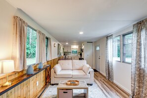 Een gezellige woonkamer met een bank, een salontafel en een houten dressoir.