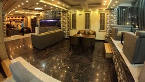 A lobby with a reception desk, seating area, and a bar. - Hotel Tara Suites (Kathmandu)
