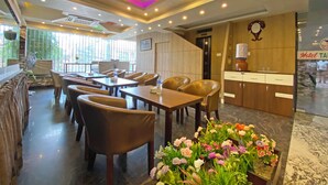 A hotel lobby with a reception desk, seating area, and a flower arrangement. - Hotel Tara Suites (Kathmandu)