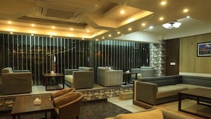 A modern lounge area with sofas, armchairs, and a coffee table. - Hotel Tara Suites (Kathmandu)
