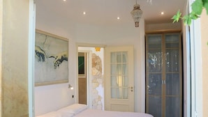 A bedroom with a bed, a door with frosted glass panels, and a wall-mounted artwork. - Casa Libezia A: A welcoming apartment located right on the beach, with Free WI-FI. (Augusta)