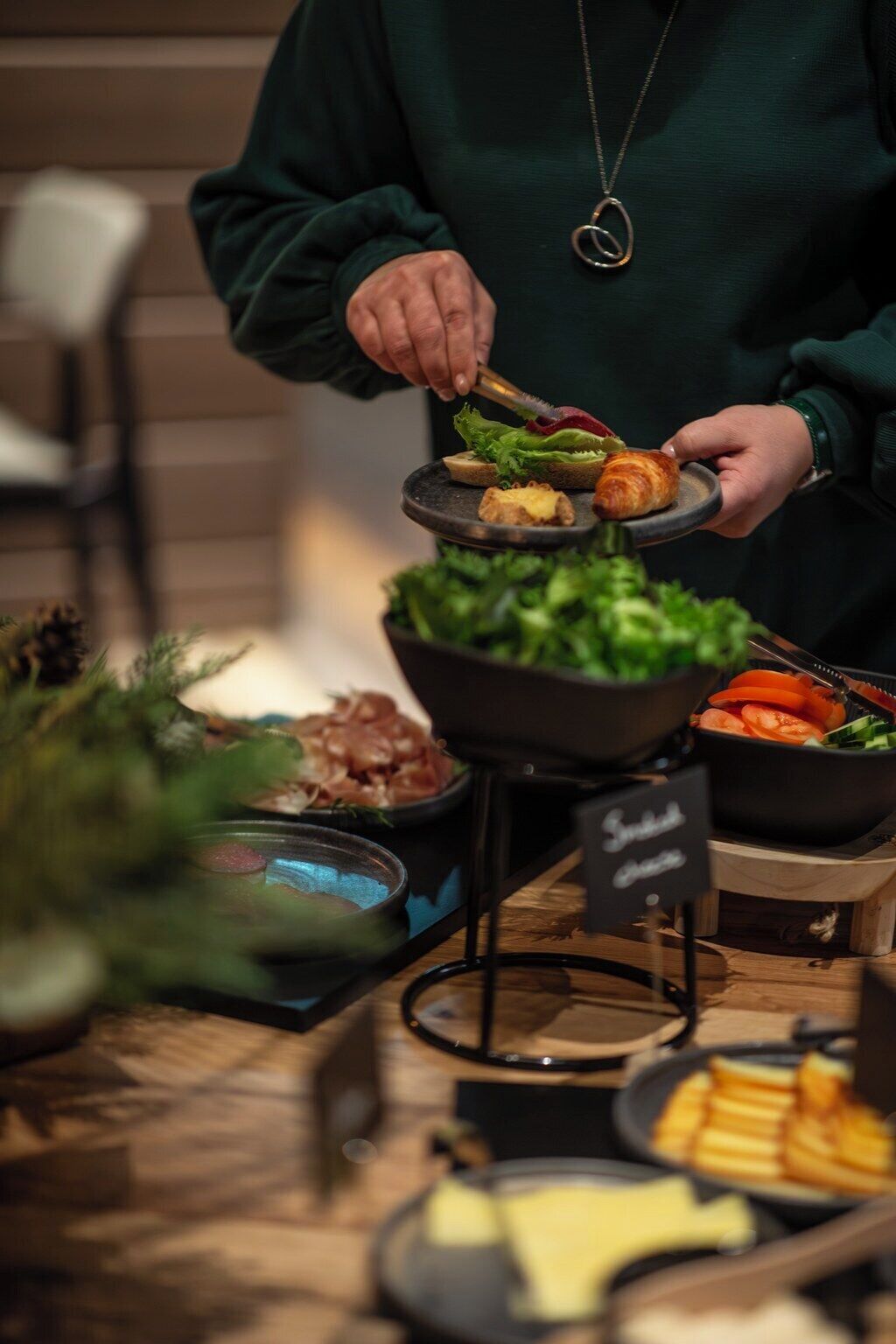 A buffet setup with various food items including bread, salad, and meats.