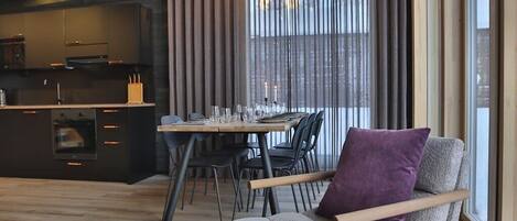 Un soggiorno moderno con zona pranzo, cucina e ampie finestre.
