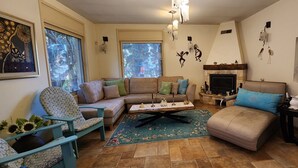 A living room with a sofa, armchairs, a coffee table, a fireplace, and wall decorations. - Welcoming villa with AC in charming Herut with calm atmosphere and lot of space (Herut)