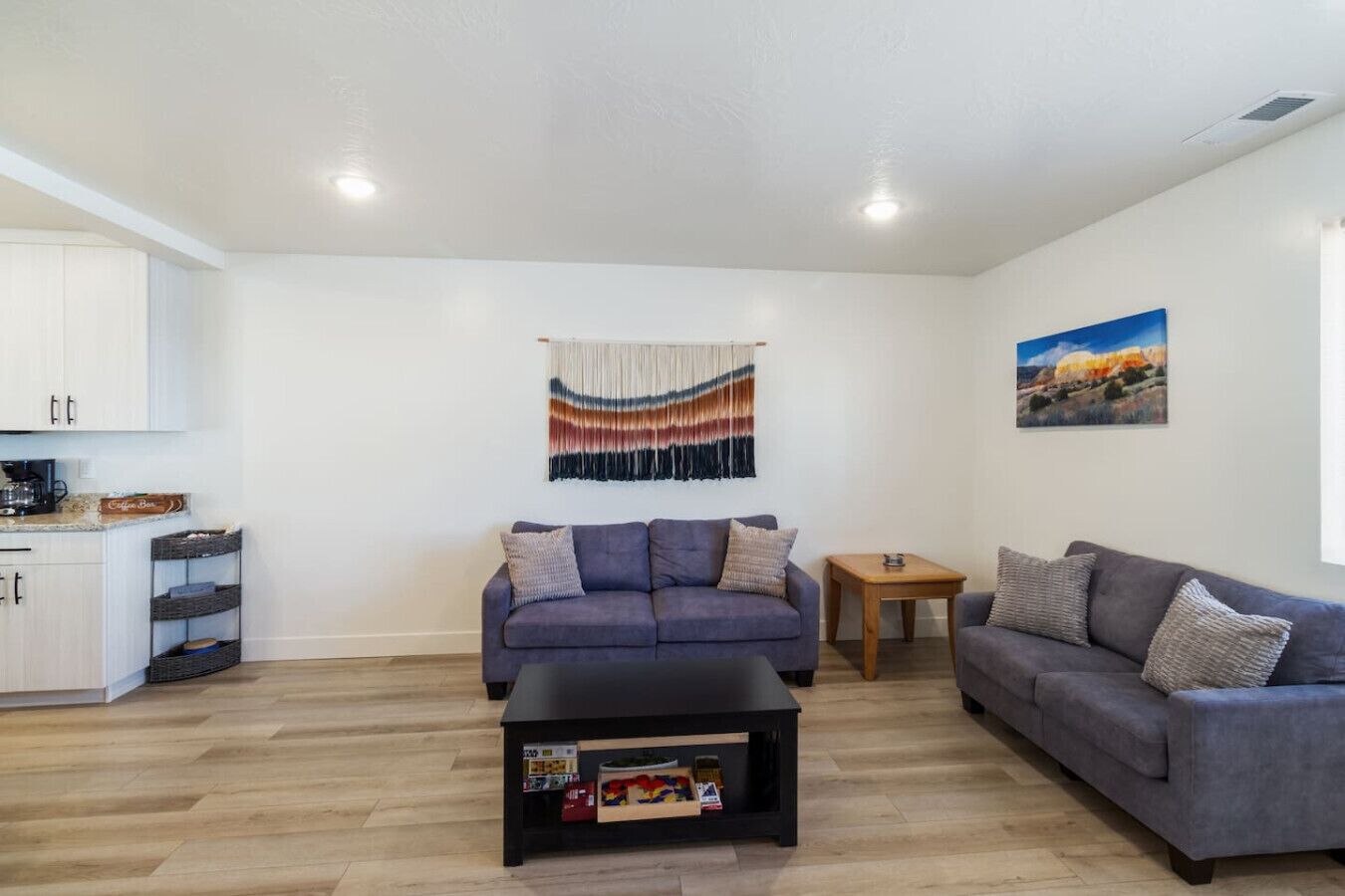 A modern living room with a sofa, a coffee table, and a small wooden table.