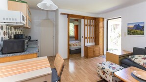 A compact living space with a kitchenette, a dining area, a sofa, and a bed. - Holiday Home 'Krohse' with Shared Garden and Wi-Fi (Potsdam)