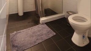 Ein Badezimmer mit Dusche, Waschbecken und Toilette.