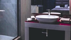 A modern bathroom with a large mirror, a round sink, and a shower area. - HOTEL EL PAMAS (Mugnano di Napoli)