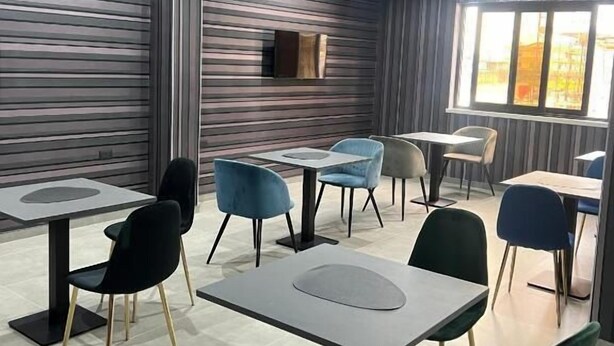 A modern dining area with contemporary furniture and a large window providing natural light. - HOTEL EL PAMAS (Mugnano di Napoli)