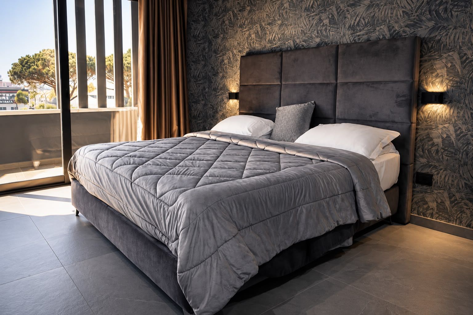 Un dormitorio moderno con una cama grande, cabecera con iluminación integrada y vistas al exterior.
