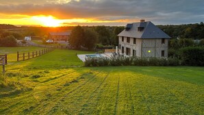 Une grande maison de style rustique, dotée d’un toit en pente et d’une cour clôturée.