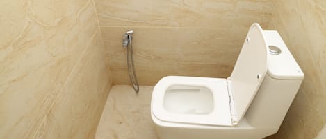 Une petite salle de bain moderne, équipée de toilettes et d’une douche.