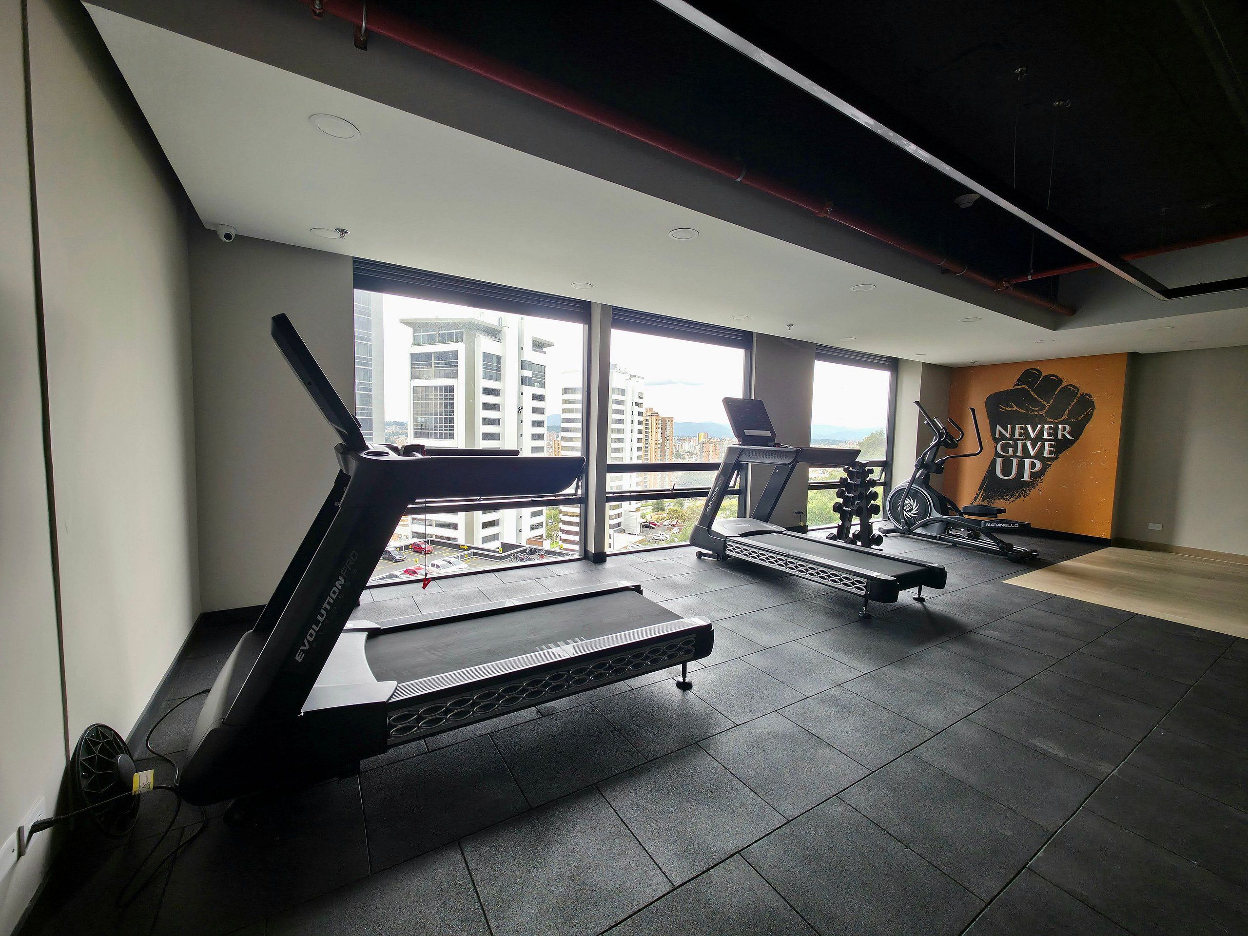 A gym with treadmills, a stationary bike, and a motivational wall.